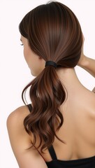Fototapeta premium an individual with long curly brown hair styled as a ponytail against a white backdrop