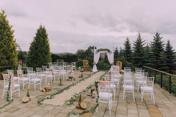 A wedding ceremony is taking place in a beautiful outdoor setting. The ceremony is taking place in...
