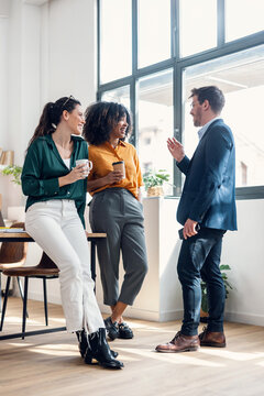 Business people taking a break of work while drinking a cup of coffee in conference room at modern startup