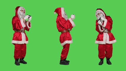 Santa claus having fun with videogames, playing online gaming competition and standing over full...