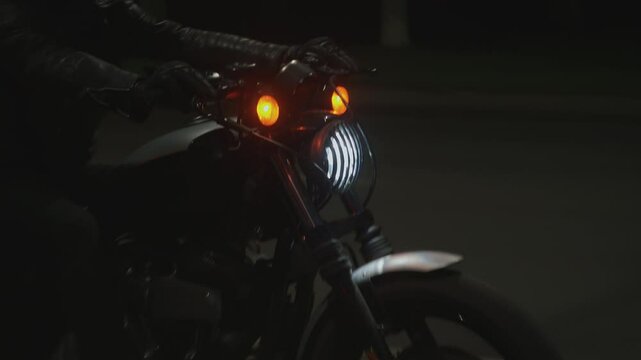 Biker wearing black helmet and black leather jacket rushes along night road. Close-up. Handheld pov shot of camera. Main advantage of traveling by motorcycle is ease and feeling of freedom