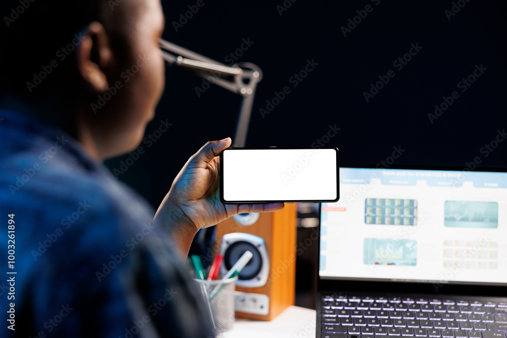 Poster close-up of freelancer working from home, using a laptop and smartphone displaying blank copyspace m