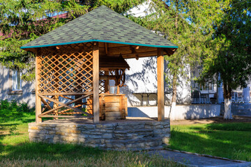Naklejka premium A wooden pavilion with a fountain in the middle