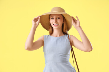 Fototapeta premium Young pretty woman in hat on yellow background