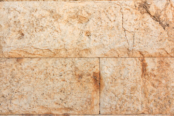 A brick wall with a rough texture and a few cracks