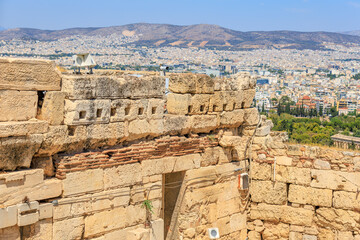 Fototapeta premium A stone wall with a window and a camera on top of it, Acropolis in Athens