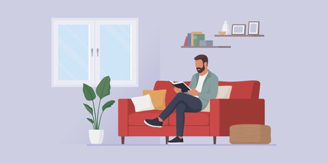 Man relaxing on the couch and reading a book