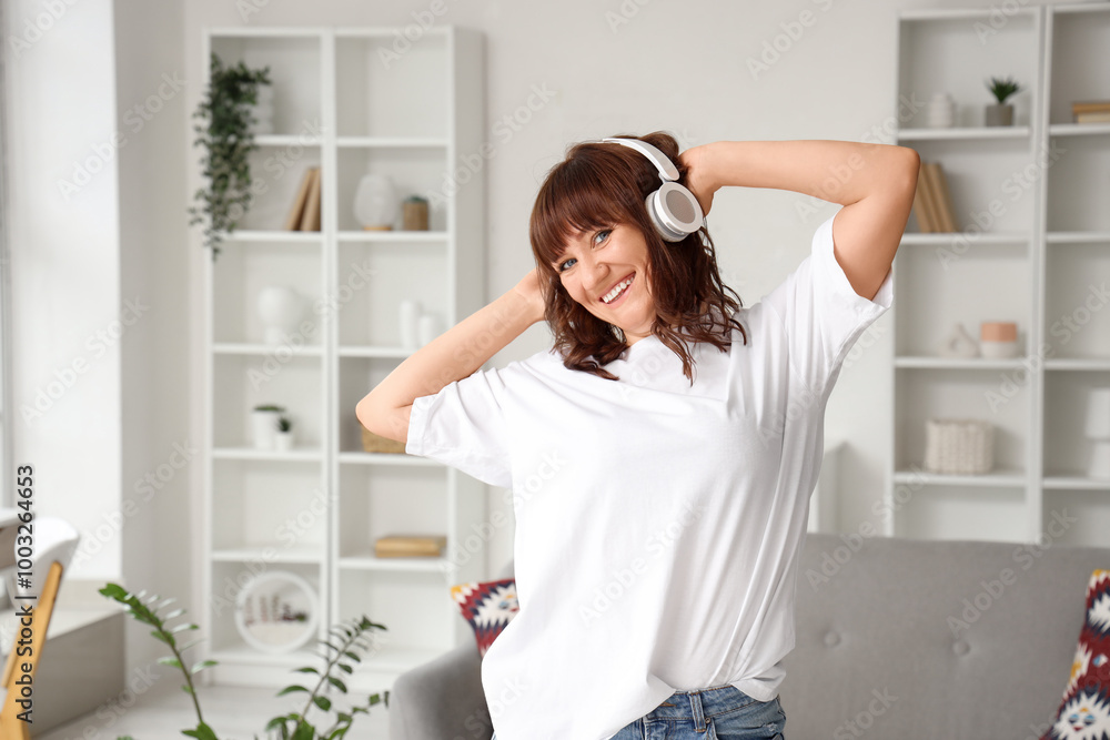 Poster Beautiful woman in headphones listening to music at home