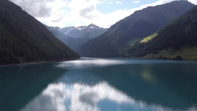 Turquoise water reflecting the blue sky of a sunny summer day at Lake Vernago in Trentino Alto Adige, Italy