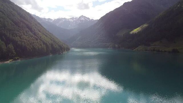 Turquoise water reflecting the blue sky of a sunny summer day at Lake Vernago in Trentino Alto Adige, Italy