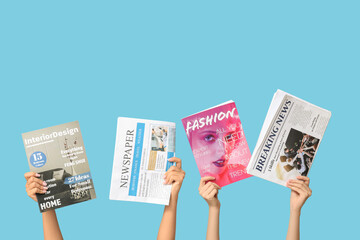 Female hands with different magazines and newspapers on blue background