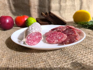 Sliced cured sausage on a white plate. High quality photos