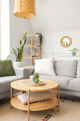 Interior of light living room with mirror, grey sofas and table