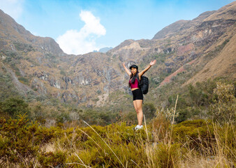 Hermosas montañas y mujer joven  con short y mochila  en el camino concepto de turismo. Paisaje con chica deportiva con top en la cima de la montaña, bosque, colinas, cielo blancos con nubes, Viaje,