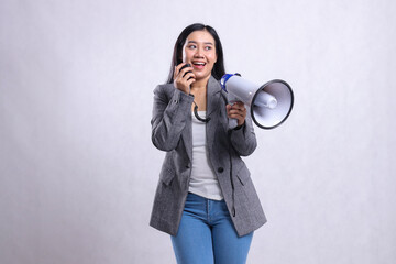 beautiful young lady shouting formal happy candid hand holding loudspeaker megaphone and microphone wearing grey suit isolated on white background. fashion, lifestyle, beauty, sale, company concept