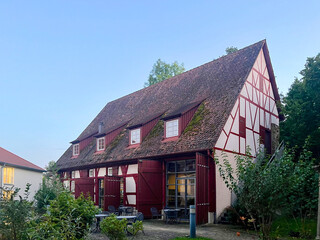Fototapeta premium Charming traditional German style house with red roof and green plants