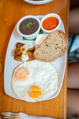 two fried eggs with various sides at organic healthy breakfast restaurant in south american city