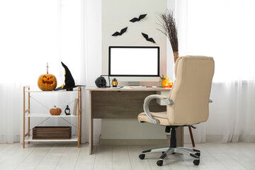 Stylish workplace with modern computer in office interior decorated for Halloween celebration