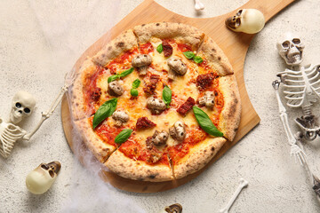 Wooden board of tasty pizza with mushrooms, bones, skulls and skeleton for Halloween celebration on white background