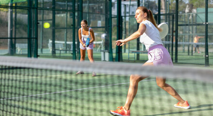 Obraz premium Portrait of two sports women tennis players playing padel on an outdoor court