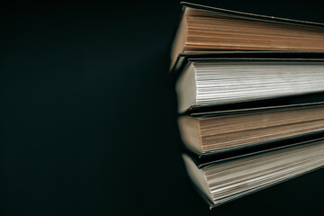 Books with black covers on a black background. Books about magic, mysticism and esotericism.Stack of books. Reading books. Reading and education.Learning and knowledge symbol. 