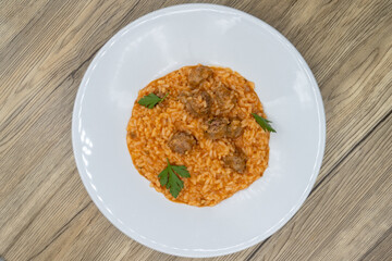 Overhead view of Italian risotto served with sausage and tomato sauce over a bed of rice