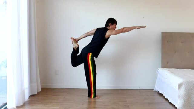 homem faz exerc&iacute;cios e alongamentos em casa 