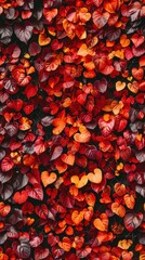 Dense wall of tiny leaves in autumn hues, deep reds and golden yellows, soft focus, ideal for warm, seasonal backgrounds.