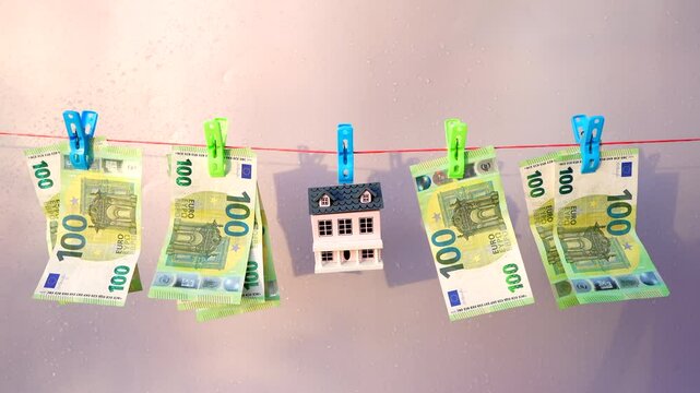 Money Laundering through Real Estate. Washed Euro note paper during drying. House and One hundred 100 euros Banknote are drying on clothesline. Money Laundering Risks in Real Estate, financial crime. 