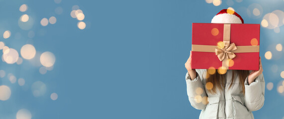 Woman with Christmas present on blue background
