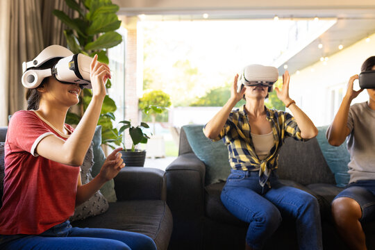 Using VR headsets, family enjoying virtual reality experience together indoors