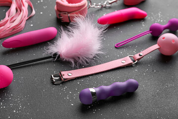 Different sex toys on grunge black background
