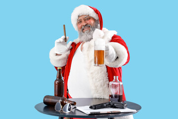 Bad Santa Claus with cigar and beer at table on blue background