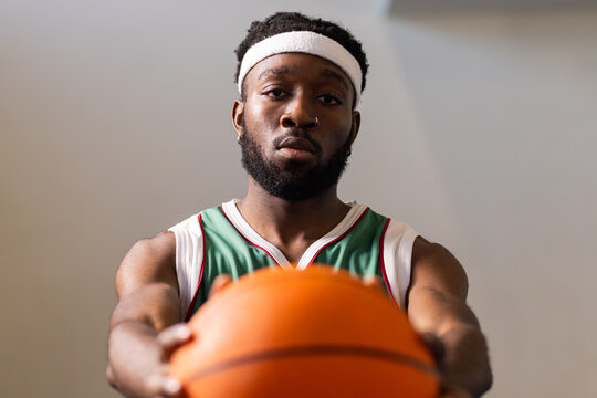 Holding basketball, athlete focusing on game in gymnasium