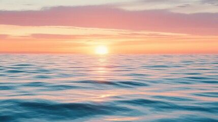 Fototapeta premium A tranquil ocean view at sunset, showcasing a vibrant color palette of pink and orange reflecting on the calm water surface.