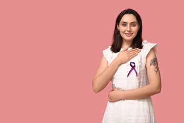 Pretty young woman with purple ribbon on pink background. Pancreatic cancer awareness concept
