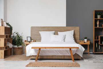 Interior of stylish bedroom with big bed and shelving unit