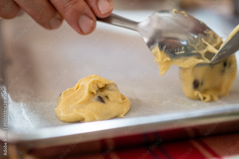 Wall mural close up on a raw cookie dough ball on a baking tray, chef baking sweet treat dessert with a spoon