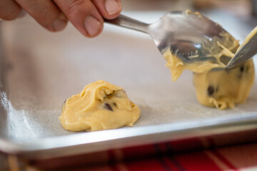 close up on a raw cookie dough ball on a baking tray, chef baking sweet treat dessert with a spoon