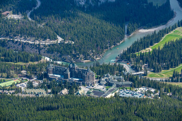 View of the stunning Fairmont Banff Springs Hotel in the town during spring time with incredible views surrounding the wilderness hotel in Canada.