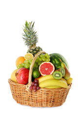 Many different fresh fruits in wicker basket isolated on white
