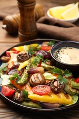Delicious salad with grilled vegetables and sauce on table, closeup