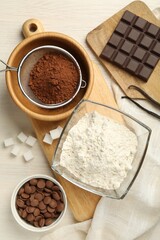 Flat lay composition with flour, chocolate and other ingredients for making dough on light table
