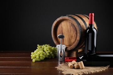 Wing corkscrew, corks, bottles of wine, grapes and barrel on wooden table