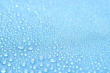 Water drops on light blue background, closeup view
