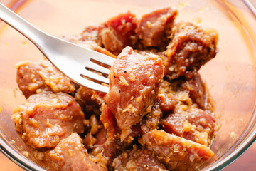 Piece of Marinated Pork Shoulder Speared on a Fork: Boston Butt chunks in lemongrass marinade for Bun Thit Nuong Vietnamese Grilled Pork