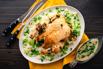 Chicken Roasted in Coconut Milk with Lemongrass Served Over Rice: Whole chicken served on a platter with jasmine rice, scallions, and cilantro