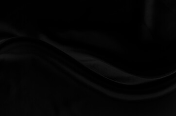 Black gray satin dark fabric texture luxurious shiny that is abstract silk cloth background with patterns soft waves blur beautiful.
