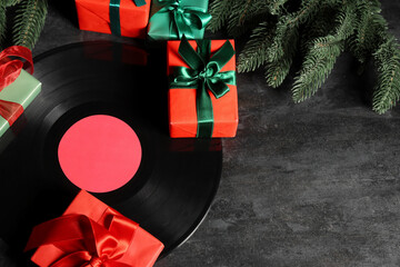 Vinyl disc with Christmas tree branches and gift boxes on black background