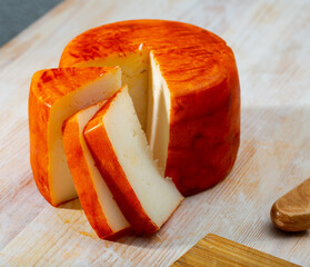 Image of tasty french goat cheese with pepper, slices at wooden desk